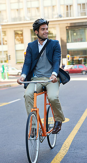 man riding bike in city wearing helmet