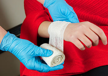 Gloved hands wrapping injured wrist