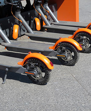 Rear wheels of line of dockless scooters - are you insured when riding a scooter?