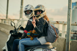 Girlfriend of motorcyclist makes a peace sign to the camera