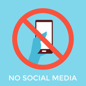 Icon of hand holding cellphone with a red circle over it crossed out - no social media
