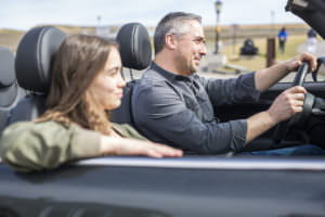 Parent safely driving a teen in a convertible