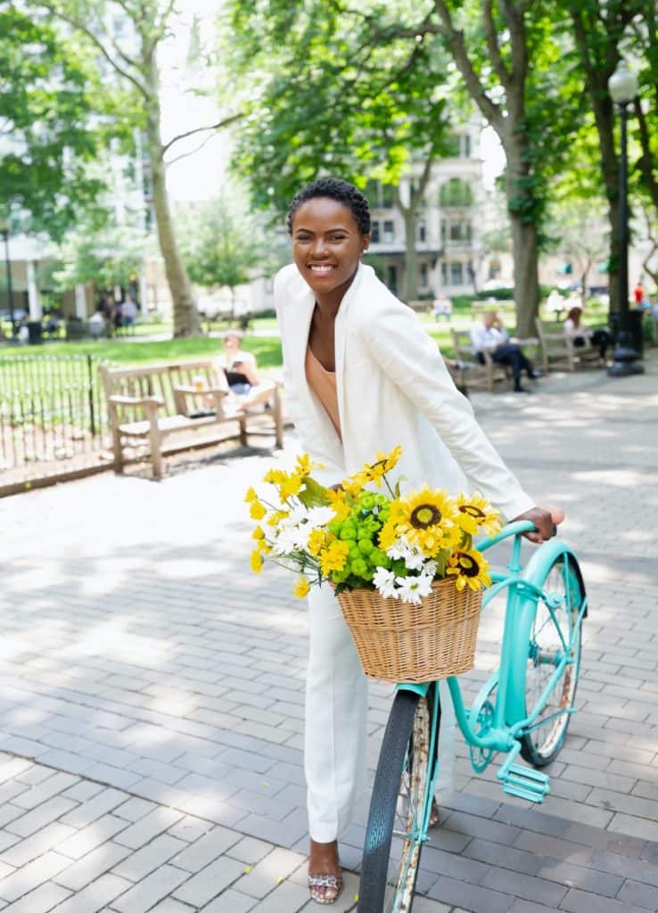 image of woman in white pantsuit on bicycle | colorado bike lawyer